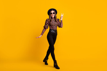 Fototapeta na wymiar Full length body size photo of cheerful woman in stylish trendy clothes showing v-sign gesture isolated vivid yellow color background