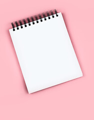 Large white notepad on a black spiral, with empty space for text, copy space on a delicate pink background. Concept - business, school, student supplies. Good quality vertical photo.