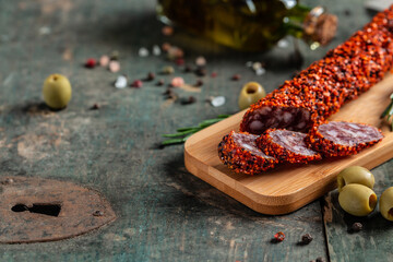 Salami sausages chorizo made with paprika and garlic on cutting board on wooden table. banner, catering menu recipe place for text, top view