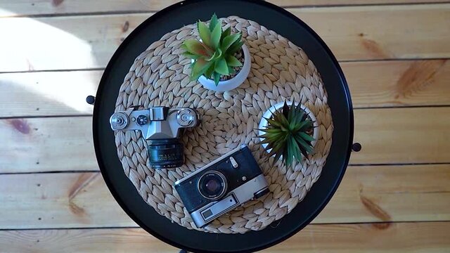 Retro camera on the table, image rotation with magnification, retro camera and cacti on the table.