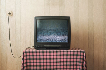 Old TV with small screen broadcasting flickering black and white image