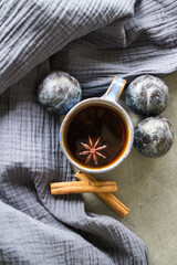 Simple still life in blue colors with ceramic cup and fresh plums. Dark grey background. 
