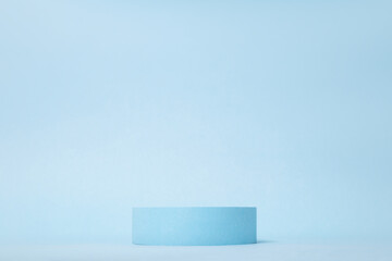Beauty products background. Cylinder on blue with copy space. Podium stand, trendy minimal geometric scene