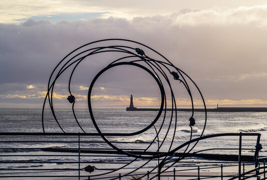 Decorative railings on Seaburn Beach with Roker Pier in the background.