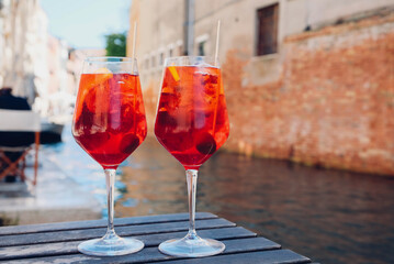Two glasses of Spritz Veneziano cocktail served near the Venetian canal.  Popular italian summer aperitif drink.