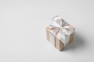 Obraz na płótnie Canvas Beige gift box with bow on white background