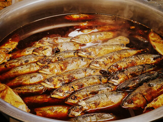 Group of Boiled Sweetened Mackerel Fish in Large Stainless Steel Bowl