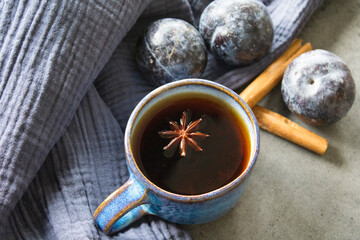 Simple still life with blue cup and plums. Grey concrete background with copy space. 