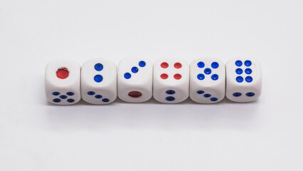 Heap of white cubic tree six dices with blue and red spikes (dots) on a white background. Game, gambling, chance and risk concept