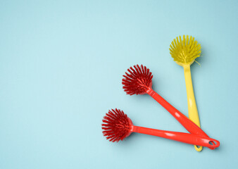 plastic brushes with handles for cleaning on a blue background