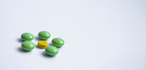 colorful round pills on white background, concept, green and yellow tablets with free copy space