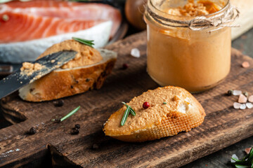 Smoked salmon and soft cheese spread, mousse, pate in a jar on toast wooden background. banner,...