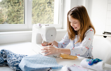 12 years old child studying work with sewing machine