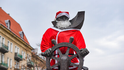 .Monument to a sailor in Szczecin dressed in a Santa Claus costume with a steering wheel. - obrazy, fototapety, plakaty