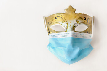 Venetian carnival mask with protective mask. Unspecified identity. Gold and blue. Light background
