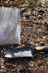 Foil bag with fertilizer. Gardening spatula. Spring care works.