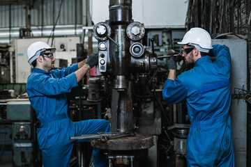Engineering man wearing uniform safety workers perform maintenance in factory working machine lathe...