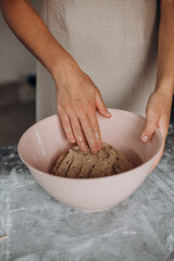Obraz na płótnie Canvas female hands kneading dough homemade bread bowl