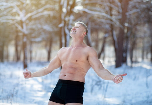 Senior man standing in underpants, showing thumbs up gesture, recommending cold resistance training at winter park