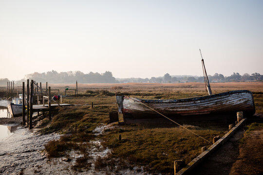 Old boat at Thornham old harbour, Norfolk, England in early morning light, backlit