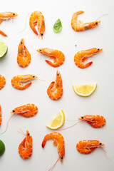 Overhead view of shrimps and lemon on light surface