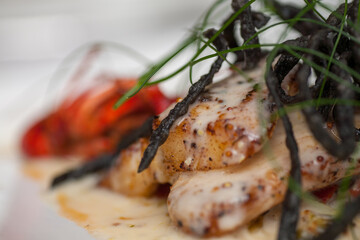 Catfish steak cooking on a grill, served with pepper sauce and seaweed in the restaurant. High quality photo