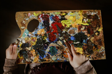 brushes, paints and palette, all for creativity in the hands of a child