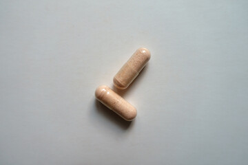 2 pink capsules of probiotic dietary supplement from above