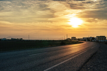 Obraz premium Road lit by the setting Sun, Morocco. 