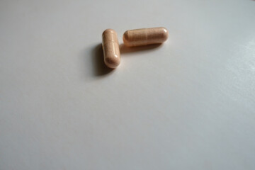 Group of two pink capsules of probiotic dietary supplement