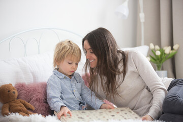 Mother and child, toddler boy, reading book in bed