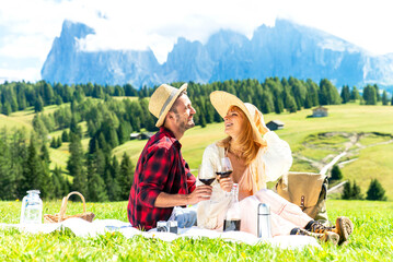 Young couple enjoying harvest time together outside at farm house vineyard countryside - Friends toasting red wine at picnic - Bright filter