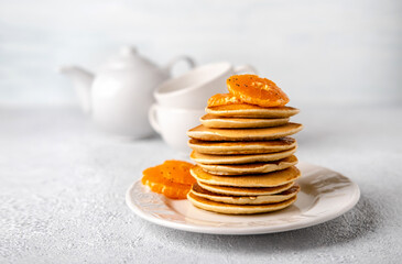Close-up delicious pancakes with tangerines for breakfast on a light background. Copy space.