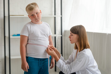 Upset boy during waistline measurement at a nutritionist's appointment