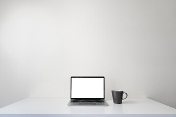 Modern contemporary workspace with blank screen laptop computer and coffee cup on office desk table...