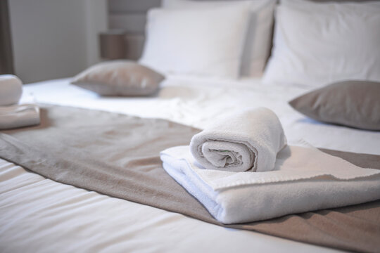 Bed in hotel room. Bed maid-up with clean white pillows and bed sheets in beauty room. Close-up. Hotel room. Modern bedroom with grey bed . Towel in Hotel Room , Welcome guests , Room service