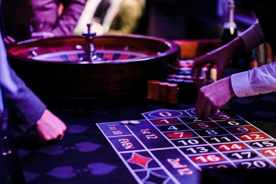 Cropped Hands Of People Gambling In Casino