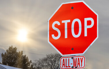 Obraz premium A 'Stop' traffic sign with the sun in the sky