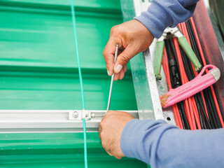 Mechanic is tighten the nut lock the ground wire of the solar panel.
