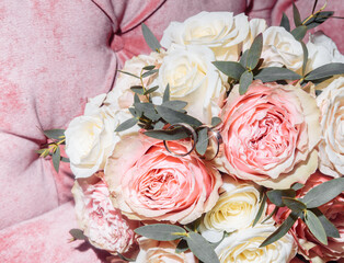 white gold wedding rings in a box and a bridal bouquet of delicate roses and greenery