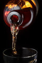 Whiskey is poured into a glass.