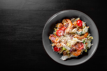 Seafood Caesar Salad with Shrimps, Salad Leaf, Croutons, Cherry Tomato and Parmesan Cheese in bowl