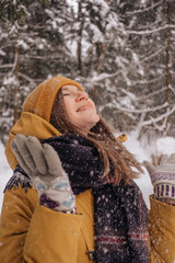 Young Cheerful woman spending time in winter snowy forest. Having fun in winter holidays