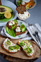 Sandwiches with soft cheese, avocado and cucumber. Breakfast is on the table. Healthy food. Toast and spread on it. Avocado sandwich stilllife. Healthy food. Toast.