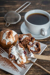 Sweet cherry muffin with ice cream and white cup with tea on a wooden background