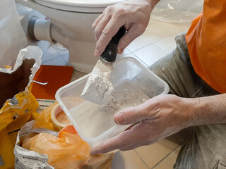 craftsman mixes the material for his work in a bathroom