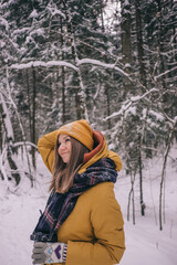 Fototapeta na wymiar Young Cheerful woman spending time in winter snowy forest. Having fun in winter holidays
