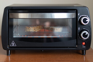 Fototapeta premium MAKING BREAKFAST TOASTS IN AN ELECTRIC OVEN