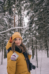 Fototapeta na wymiar Young Cheerful woman spending time in winter snowy forest. Having fun in winter holidays