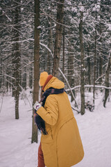 Fototapeta na wymiar Young Cheerful woman spending time in winter snowy forest. Having fun in winter holidays